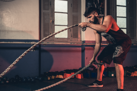 Athlete exercising with battle ropes at a gym