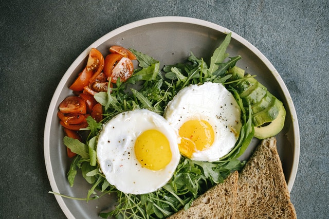 Breakfast with eggs, greens, and toast.