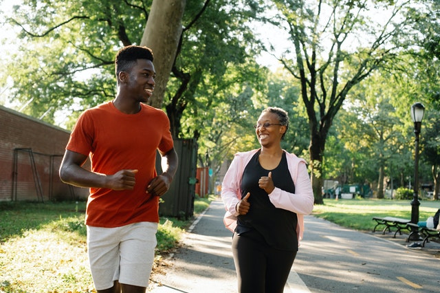 Younger athlete and older athlete jogging together.